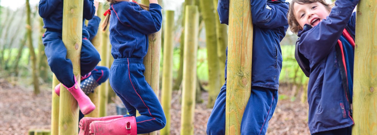 school children climbing on wooden posts