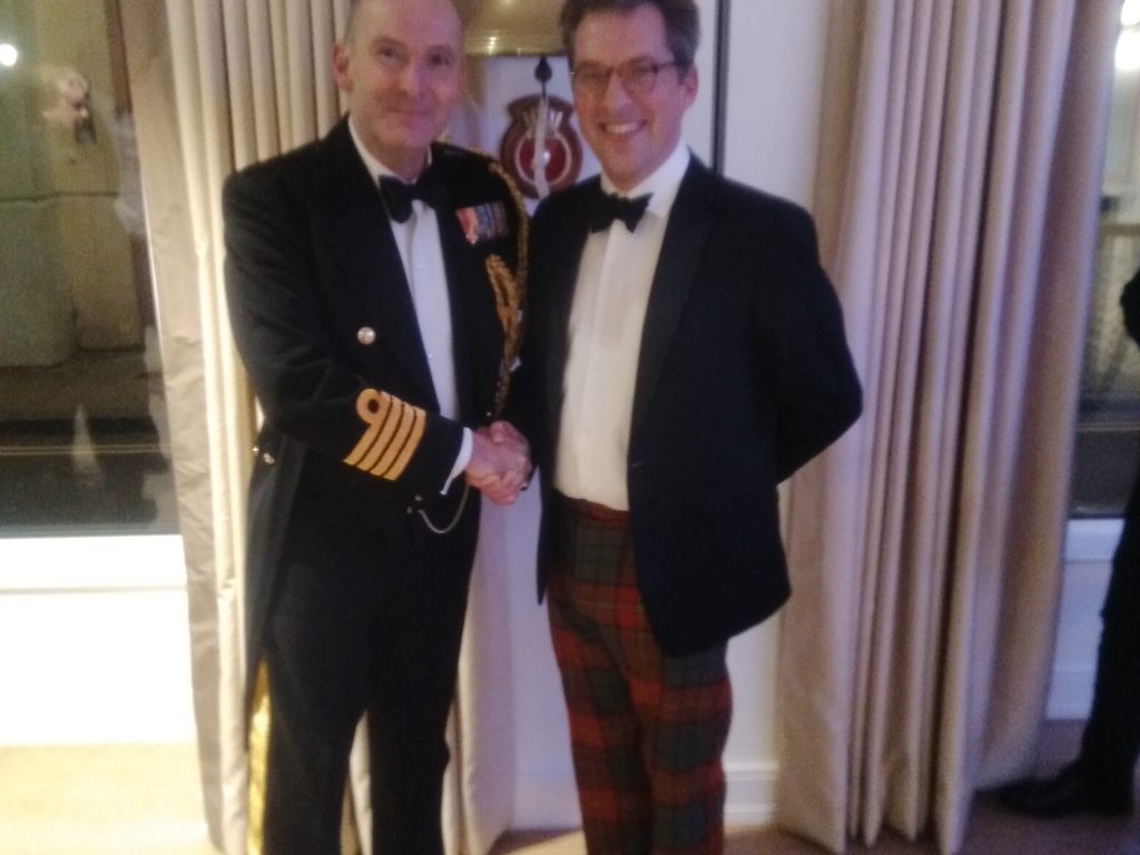 Two men in tuxedos, one with a Naval jacket and one in a pair of tartan trousers