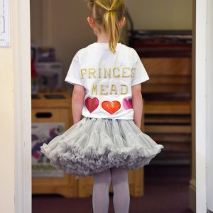 A young girl dressed as a princess, wearing a tutu and tiara.