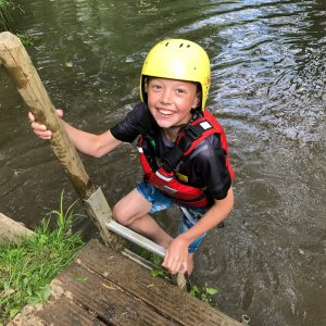 A child climbing up the ladder to exit the river