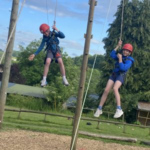 2 children using a climbing frame to practice abseiling