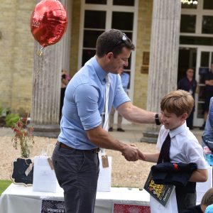 a teacher shaking hands with a pupil