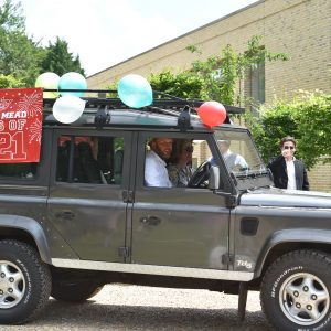 parents driving into school in a truck with balloons