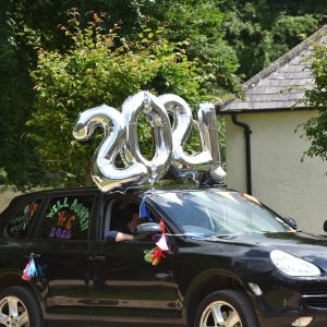 2021 balloons attached to the roof of a car