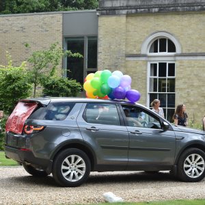 A car with balloons attached to its roof